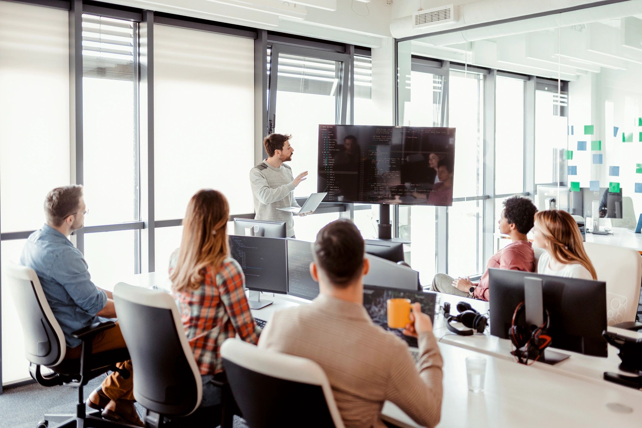 Consultants discussing a Microsoft Teams rollout plan in a modern office